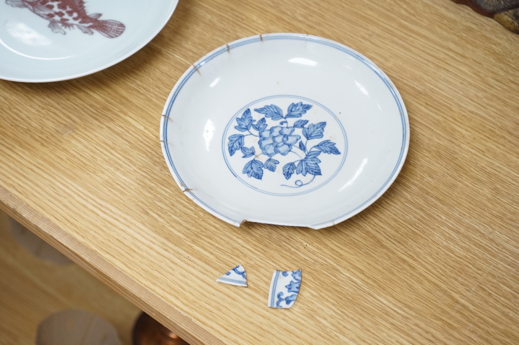 A Chinese underglaze copper red ‘fish’ dish and a blue and white dish, Zhengde mark but later, largest 22cm